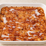 Vegan gluten-free cinnamon-raisin baked French toast with glaze in a white baking dish for your Vegan Yom Kippur Break Fast.