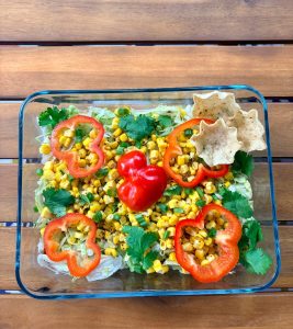 Vegan 7-layer dip with black beans, guacamole, pico de gallo, lettuce, corn and red pepper for Sukkot